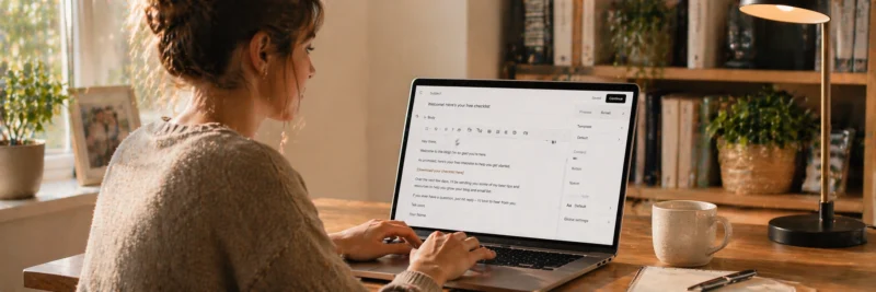 Woman writing a welcome email on laptop with email editor open showing subject line and message