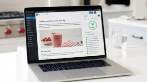 Laptop on a bright white kitchen island displaying the Rank Math SEO plugin with a fully completed green checklist and high score as part of an on-page SEO checklist for bloggers