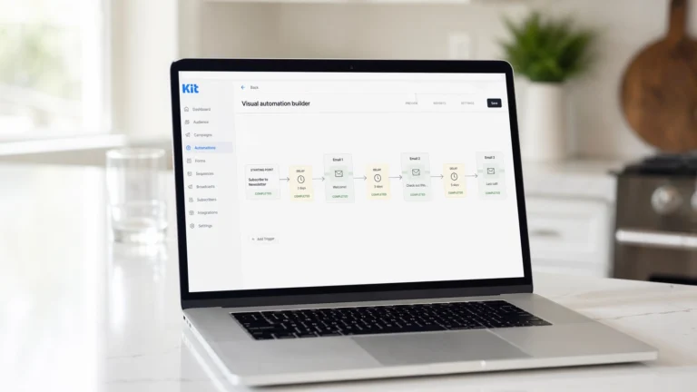 Laptop on a bright white kitchen island displaying the Kit ConvertKit visual automation builder showing an email drip campaign sequence with connected email steps and delay nodes
